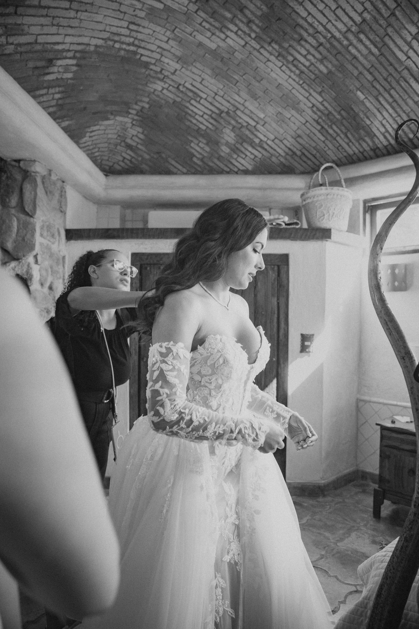 Bride getting into her gown, black and white