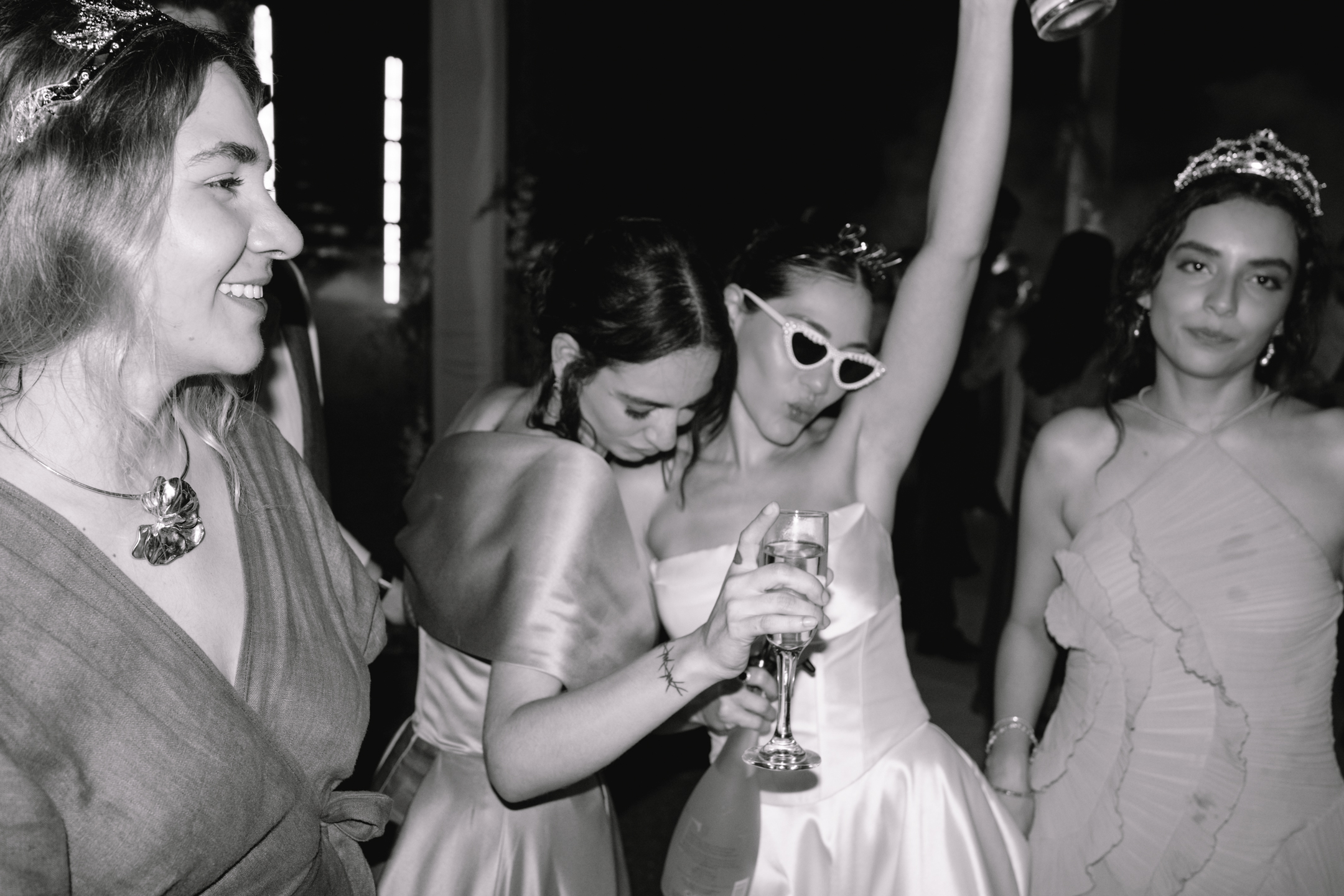 Bride celebrating with friends on the dance floor, black and white