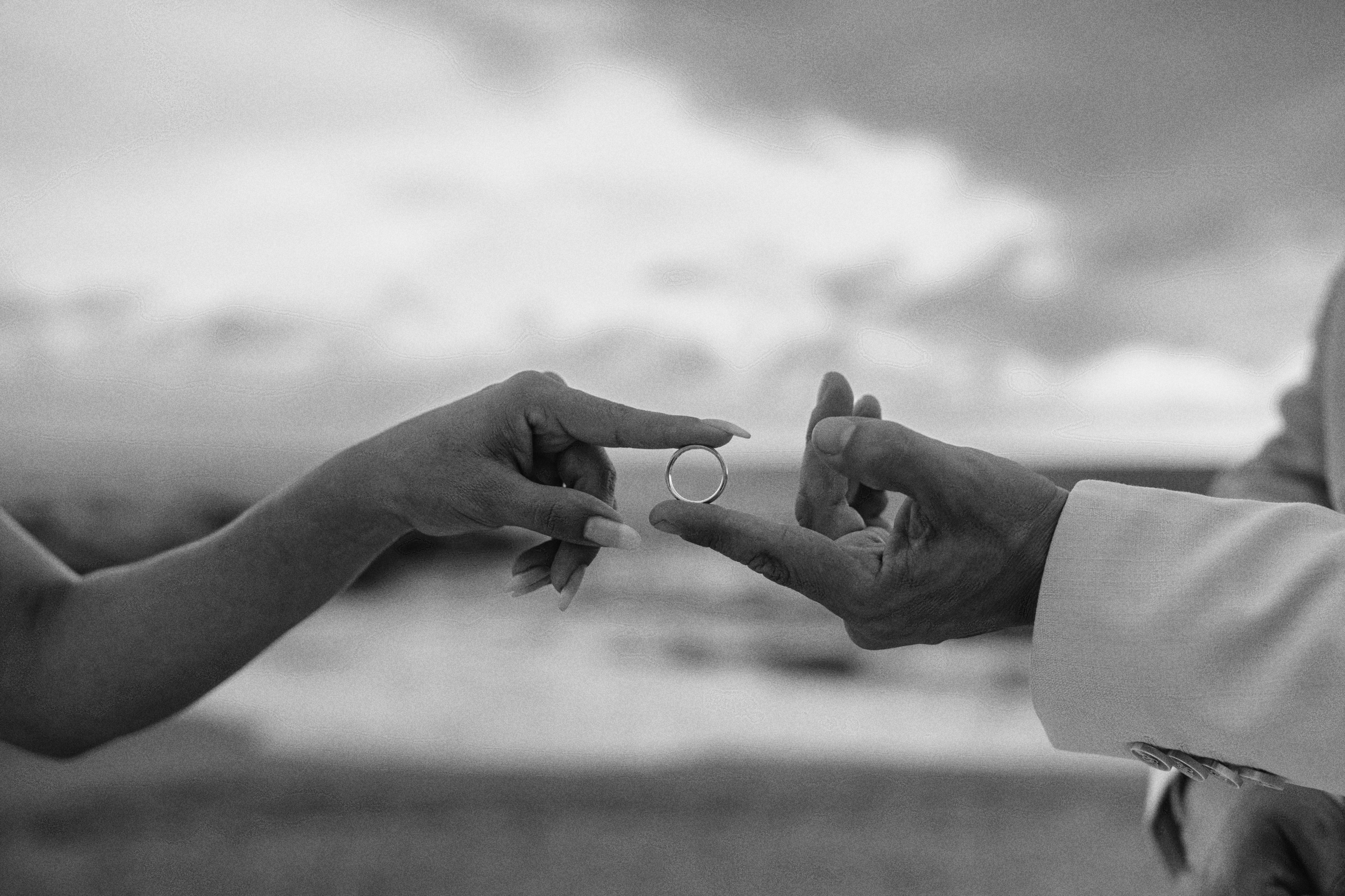 Exchanging rings on the beach, black and white