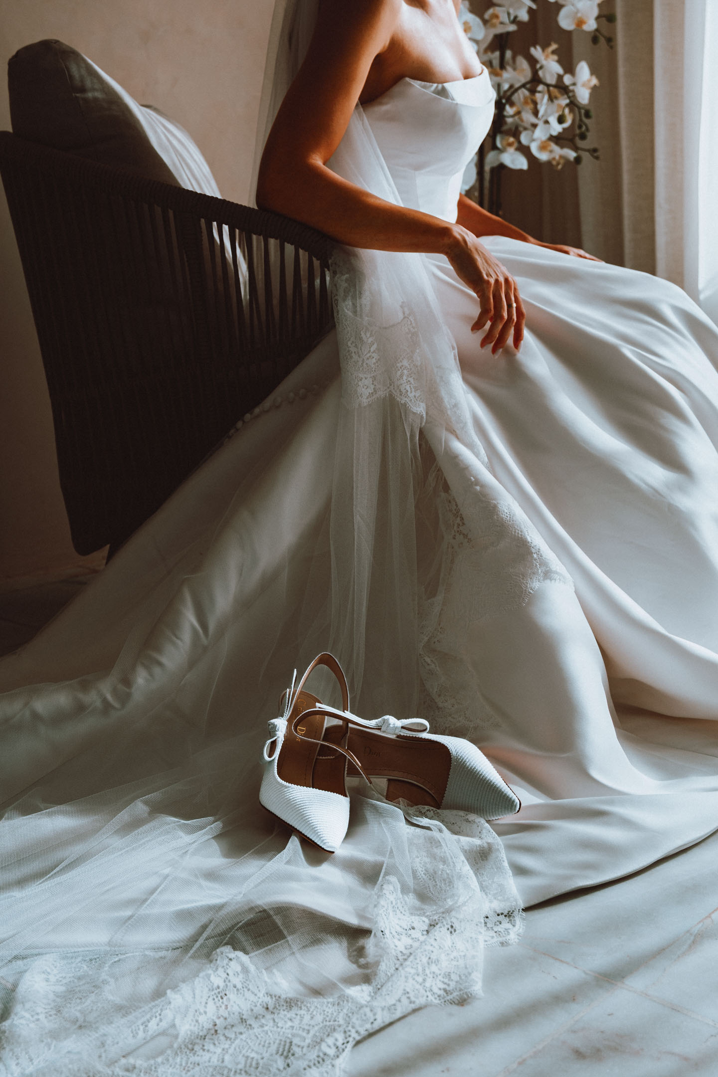 Bridal gown and Dior heels in soft window light